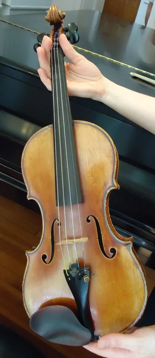 640px-Violin_held_in_hands_sunlit_angle sunlight angle of a violin